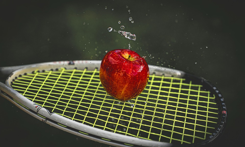 مضرب تنس مع تفاحة